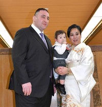 髪を整えスーツを着て写真におさまる（左から）栃ノ心、息子の春伶馬君、妻の英美さん(2024年)