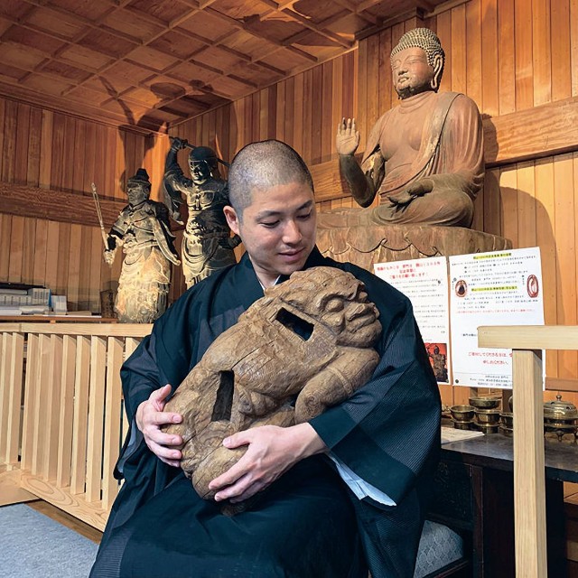 安らかな表情を浮かべる邪鬼を抱っこする林義将住職（愛知県豊橋市・普門寺）＝提供写真