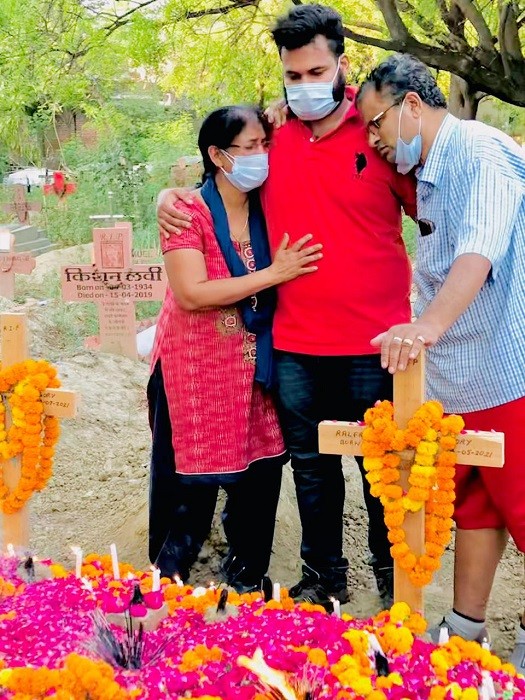 Gregory Raymond Raphael and his wife, Soja Gregory grieve with their older son Nelfred Raphael Gregory at St Luke's cemetery after the burial of their twin sons Joefred and Ralfred in Meerut, near New Delhi, in May 2021. The touching story of the twins who lived and died together has spread fast and wide on Indian social media, puncturing this nation's numbing statistics — the daily COVID-19 case numbers, the death counts, the infection rates. (Gregory Raymond Raphael via The New York Times)  -- NO SALES; FOR EDITORIAL USE ONLY WITH NYT STORY SLUGGED INDIA TWINS VIRUS BY JEFFREY GETTLEMAN and SUHASINI RAJ FOR MAY 19, 2021. ALL OTHER USE PROHIBITED. --