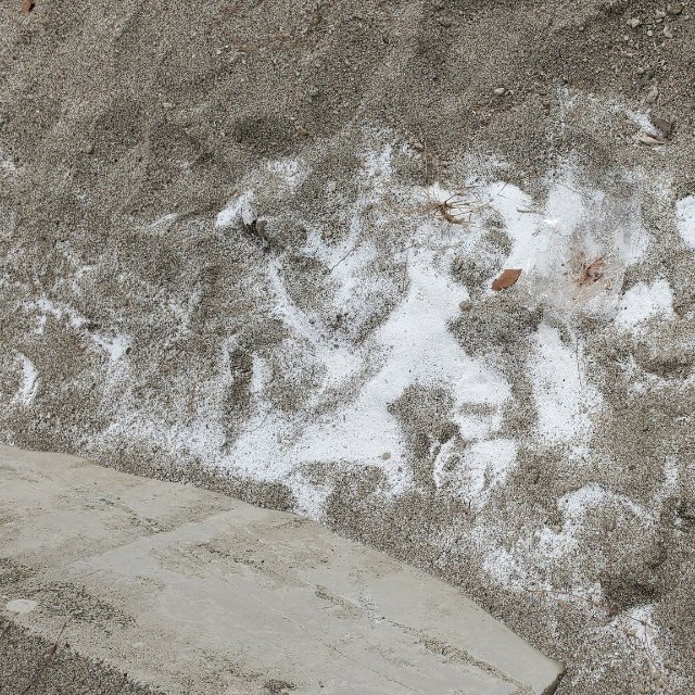 海岸のテトラポッド周辺にまかれたビーズ。近くには詰め替え用の製品を開けたとみられる袋も（浜本麦さん提供）
