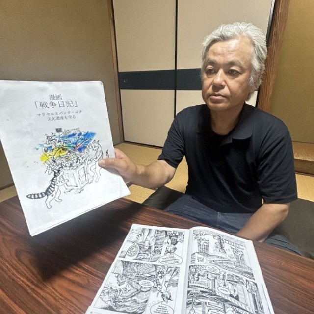 和訳した漫画を手に「共通の歴史を持つ地域として戦争を身近に考える機会になれば」と語る三田さん