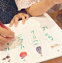 2歳の妹のひらがなドリルを丸つけする10歳の上女（画像提供：サメ美さん）