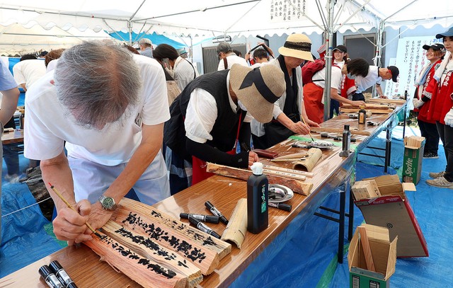 割り札や割り木に願い事などを書き込む市民たち。五つの志納所は距離がある（２０２４年８月１４日、京都市左京区・八神社）