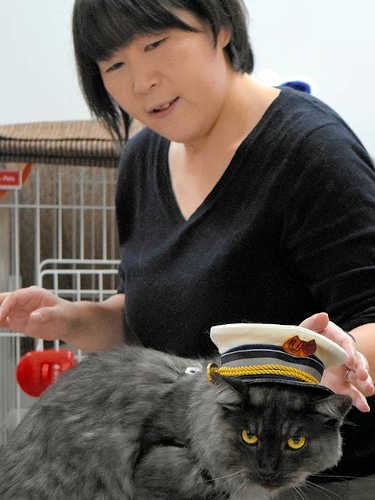 「駅長」の制帽をかぶったしょこらと細谷さん