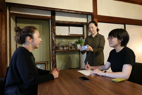 カフェの店主に取材する西田さん（右）と坂本さん（中央）＝京都市西京区大原野南春日町・古民家ｃａｆｅうよもん