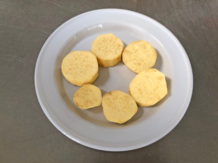 3.サツマイモは厚さ2cm程度に切って耐熱皿に並べ、ラップをかけて電子レンジで3分ほど、竹串がすっと通るようになるまで加熱する。ラップを外して冷ます。