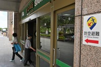 台北駅の出入り口に貼られた、防空壕を示す新たなデザインの標識。駅の地下街が壕を兼ねている＝台北市、石田耕一郎撮影