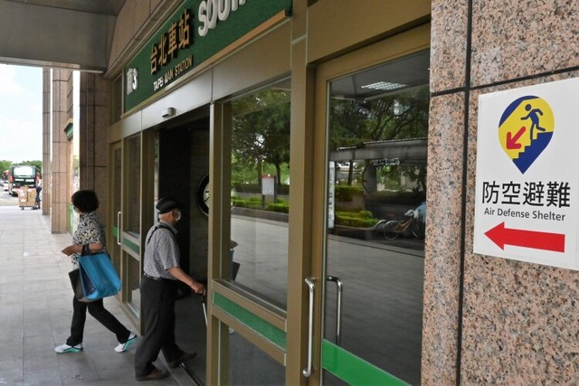 台北駅の出入り口に貼られた、防空壕を示す新たなデザインの標識。駅の地下街が壕を兼ねている＝台北市、石田耕一郎撮影