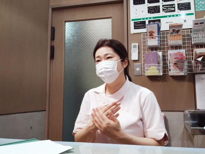 手話で「お大事に」を表現する小原さん。手話を学び始めた理由は、次回ご紹介！（小原さん提供）