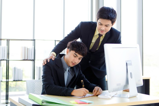 部下に仕事を教えている先輩※画像はイメージです （Bangkok Click Studio/stock.adobe.com）