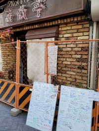 火災で休業中の老舗定食店「薔薇亭」。フェンス前にメッセージボードが２つ置かれた=東京・高円寺