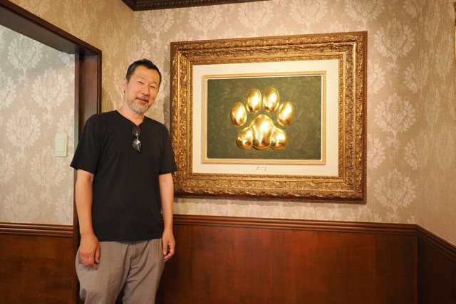 入口の猫族歴史博物館のシンボルマークと、父・徹さん