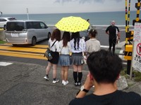 「スラムダンクの聖地」となった踏切で記念撮影する若い中国人女性も多い＝神奈川県鎌倉市