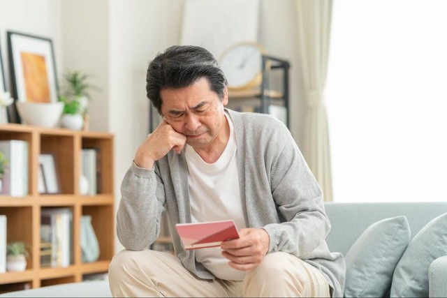 通帳を見ながら家計について考える男性※画像はイメージです（dimlight/stock.adobe.com）