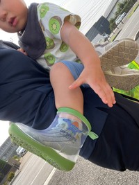 キウイ柄のTシャツを着て抱っこされるお子さん／おむろんさん（@omuron_0916）提供