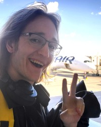 日本に到着したサムさん。飛行機を背に、笑顔で記念撮影をしました（画像提供：サムさん）