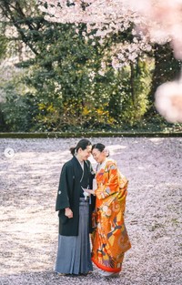 新山はるのさんと祁答院（けどういん）雄貴さん　桜の下で額を寄せ合う2人