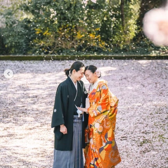 新山はるのさんと祁答院（けどういん）雄貴さん　桜の下で額を寄せ合う2人