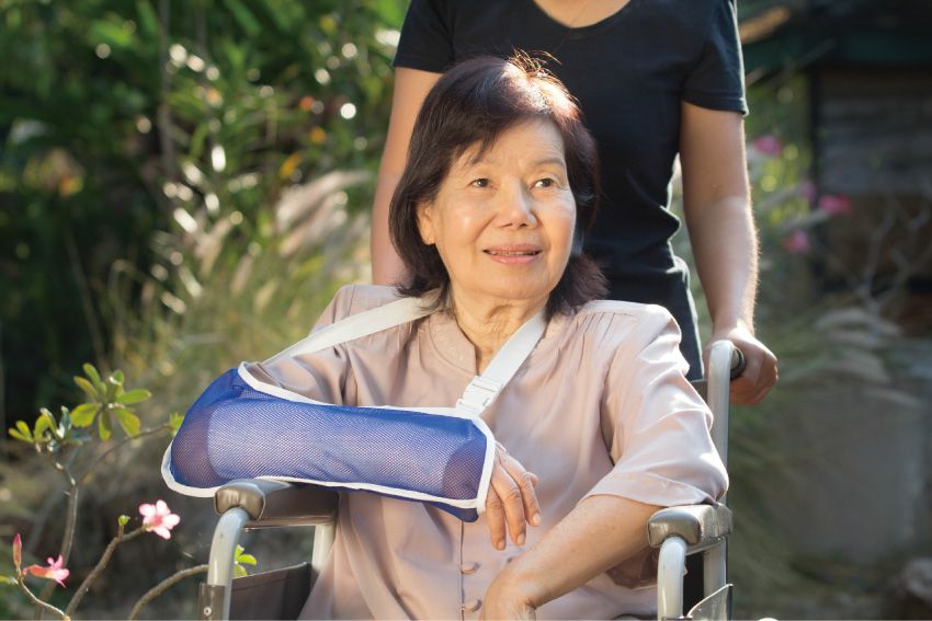 車椅子に乗る、腕を骨折した女性、Getty Images
