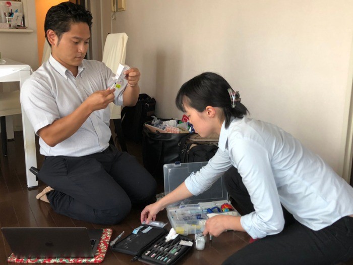 往診先で薬などの準備をする江本院長（左）と動物看護師の須之内さん