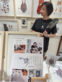 自ら描いた猫デザインうちわを手に「新宿にゃあ博」でたたずむ川上麻衣子＝都内の小田急百貨店新宿店７階イベントスペース