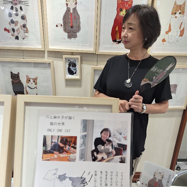 自ら描いた猫デザインうちわを手に「新宿にゃあ博」でたたずむ川上麻衣子＝都内の小田急百貨店新宿店７階イベントスペース