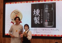 総合１位に輝いた「ほりにしブラック」の担当者（左）と審査員長のＭＩＣＨＩＫＯ氏