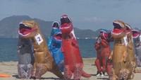 観音寺市の有明浜を疾走するティラノサウルスの着ぐるみ