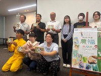 カルタの完成を喜ぶアーティストや、制作に協力した農畜水産業者ら＝岡山市北区駅元町