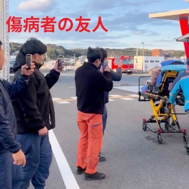 救急搬送される傷病者をニヤニヤしながら撮影する友人たち……の様子を志摩市消防本部の職員さんたちが再現（動画からキャプチャー／提供：志摩市消防本部【公式】）