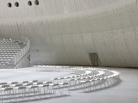 ＥＸＰＯホール「シャインハット」の内部。円形劇場の壁面を白く波打つような布が包み込む（大阪市此花区・夢洲）＝伊東豊雄建築設計事務所提供