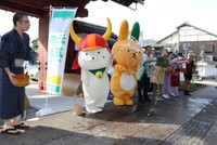 「夢京橋キャッスルロード」で打ち水をするひこにゃん（２０２４年７月、彦根市本町２丁目）