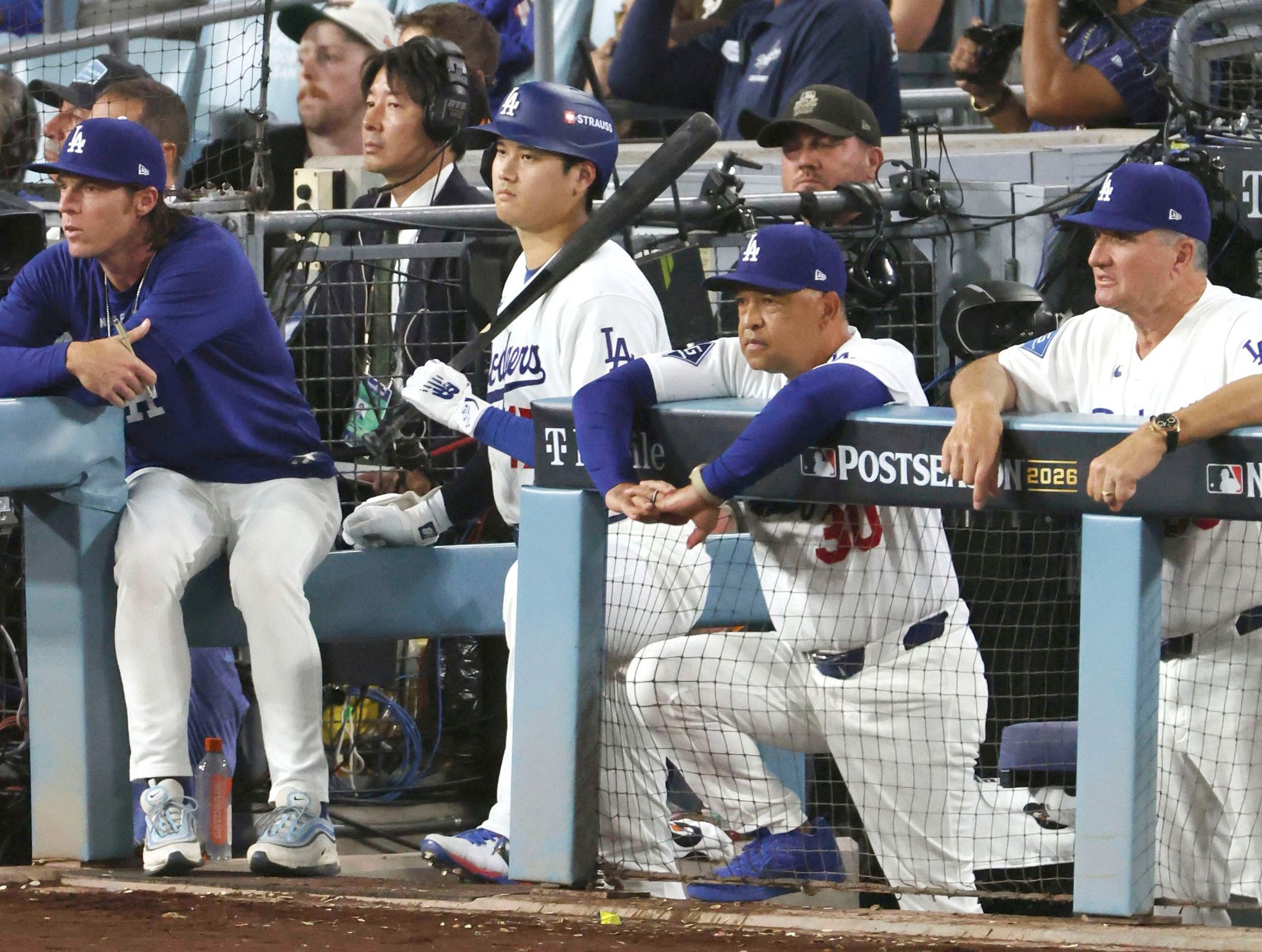 ブルワーズとのリーグ優勝決定シリーズで、リードを許す展開にベンチでさえない表情を見せるドジャースのロバーツ監督（中央右）と打席の準備をする大谷（同左）。4連敗でポストシーズン敗退が決まった＝15日、ロサンゼルス（共同）