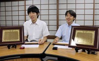 そろばんの段位認験で、十段に満点合格した磯貝さん（右）と三原さん。手前にあるのは栄誉をたたえる盾＝京都市中京区