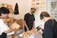 笑顔で接客する洋一さん（中央）と詠子さん（左）