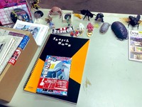 デスクには単行本『トラックドライバーの怪談 FIRST GEAR』のほか、フィギュアもいっぱい ※ぞうむしプロさん提供