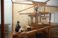 ジャカード織機がフランスから日本へ入ってくる前は、経糸を持ち上げる作業は織機の上にいる人が担当し、二人がかりで制作していました。経糸は細く約5000本もあるため、当時は緻密な柄を織ることが叶いませんでした（2026年7月撮影）