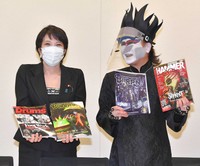 デーモン閣下（右）からヘビメタ雑誌をプレゼントされ、笑顔を見せる高市早苗氏＝2021年9月24日（撮影・出月俊成）
