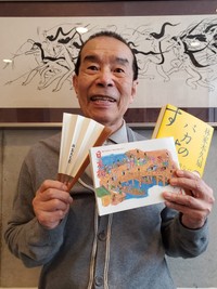 イラストレーターとして今年４月から描く月刊タウン誌「日本橋」の表紙を手にする林家木久扇。絵の師匠・清水崑さんの作品を背に「バカのすすめ」を説いた＝都内
