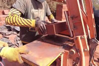 人力の圧縮機械を使い、土れんがをつくる「エレメンテール」の作業員ら＝2023年12月23日、セネガル西部、荒ちひろ撮影