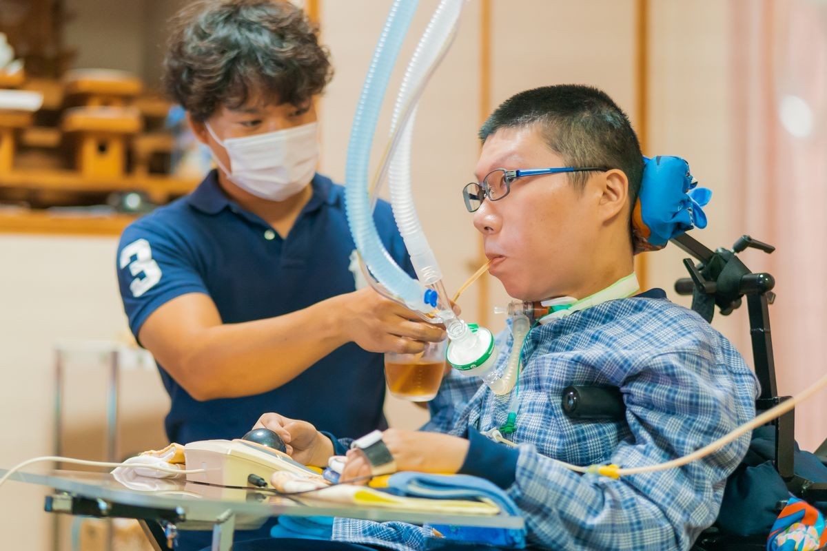 利用者とケアする職員（提供写真）