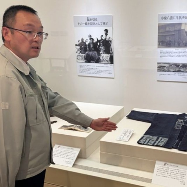 朝ドラ「ばけばけ」の衣装の参考となった牛乳店の法被を紹介する新庄正典主任学芸員＝島根県松江市、松江歴史館
