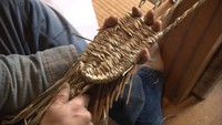 力強い手つきで草履を編んでいく