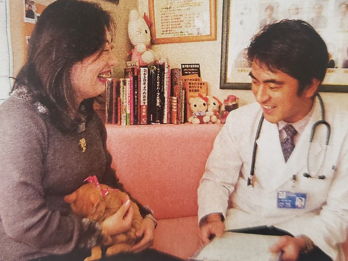 幼いトラを抱く友香子さんと、タマ、ミケ、チビ、ニャン……と続けて診た白井活光先生（週刊朝日2005年より）。先生も「猫を通じて20年近く親交を続けるのはすごいですね」