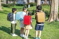 従来の赤と黒の革製ランドセルと、軽量化した「セカンドランドセル」を使い分ける小学生（布製ランドセルは「ラクサックジュニア」）