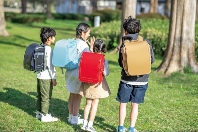 従来の赤と黒の革製ランドセルと、軽量化した「セカンドランドセル」を使い分ける小学生（布製ランドセルは「ラクサックジュニア」）