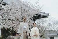 和装姿で笑顔を見せる2人。背景には京都の寺院と満開の桜／投稿主さん提供