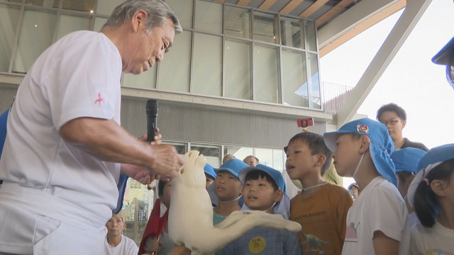 園児の前でだんごで馬を作っていく菓子職人の岡さん