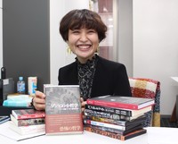 福田安佐子助教が手に持っているのは、自身が翻訳を担当した「ゾンビの小哲学」（マキシム・クロンブ、人文書院）。「増刷がかからないと印税が入りません！（笑）」＝国際ファッション専門職大学