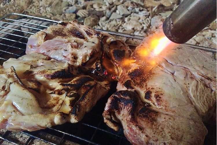 作品「戦争の果汁」制作のため、肉をバーナーで焼いた